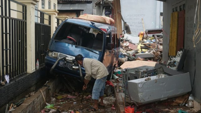 Seorang warga mencari barang berharga di antara reruntuhan puing-puing bangunan rumahnya yang hancur akibat tsunami di Desa Way Muli, Rajabasa, Lampung Selatan, Rabu (26/12). (Foto: Nugroho Sejati/kumparan)
