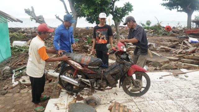 Sejumlah warga mencari barang berharga di antara reruntuhan puing-puing bangunan rumahnya yang hancur akibat tsunami di Desa Way Muli, Rajabasa, Lampung Selatan, Rabu (26/12). (Foto: Nugroho Sejati/kumparan)
