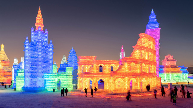 Pengunjung menikmati gemerlap lampu di dunia salju Harbin, Heilongjiang, Cina. (Foto: STR / AFP)