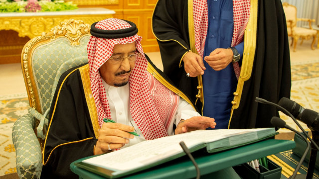 Raja Salman menandatangani dokumen untuk anggaran 2019 di Riyadh, Arab Saudi. Foto: Bandar Algaloud/Courtesy of Saudi Royal Court/Reuters