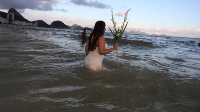 Para penganut kepercayaan Afro Brasil menghormati Yemanja, Dewi laut, menjelang New Tahun malam di Pantai Copacabana, Rio De Janeiro, Brasil. (Foto: REUTERS/Pilar Olivares)