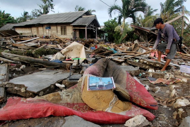 Warga memeriksa bekas reruntuhan rumah yang rusak diterjang tsunami di Dusun Tiga Regahan Lada, Pulau Sebesi, Lampung Selatan, Minggu (30/12/2018).  (Foto: ANTARA FOTO/Adam Bariq)