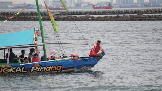 Pengunjung menaiki wahana perahu di kawasan Pantai Karavan Ancol. (Foto: Nugroho Sejati/kumparan)