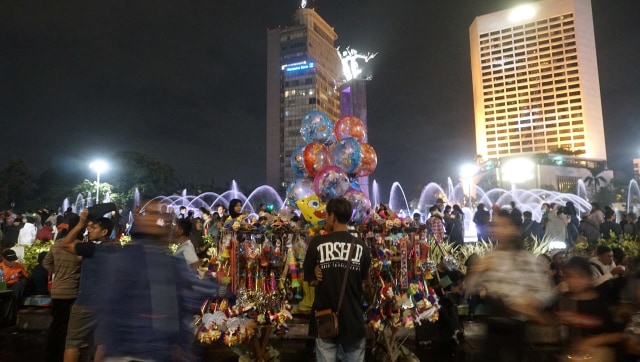 Warga memadati kawasan Bundaran Hotel Indonesia jelang malam pergantian tahun baru 2019, Jakarta, Senin (31/12). Hujan tak mengurungkan niat warga untuk menyambut malam tahun baru di kawasan Bundaran HI. (Foto: Fanny Kusumawardhani/kumparan)