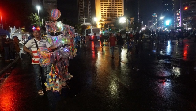 Warga memadati kawasan Bundaran Hotel Indonesia jelang malam pergantian tahun baru 2019, Jakarta, Senin (31/12). Hujan tak mengurungkan niat warga untuk menyambut malam tahun baru di kawasan Bundaran HI. (Foto: Fanny Kusumawardhani/kumparan)