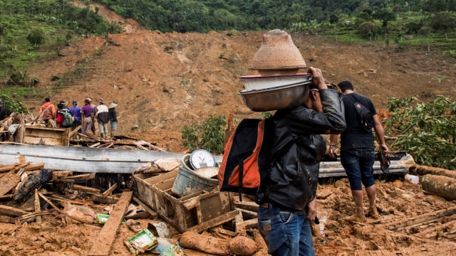 Sejumlah warga dan relawan melihat lokasi tanah longsor di Kampung Cimapag, Desa Sirnaresmi, Kecamatan Cisolok, Kabupaten Sukabumi, Jawa Barat, Selasa (1/1/2019). (Foto: Antara/M Agung Rajasa)