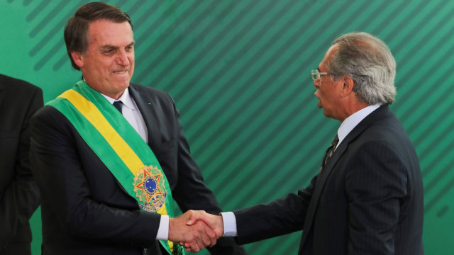 Presiden baru Brasil Jair Bolsonaro (kiri) berjabat tangan dengan Menteri Keuangan baru BrasilPaulo Guedes. (Foto: AFP/SERGIO LIMA)