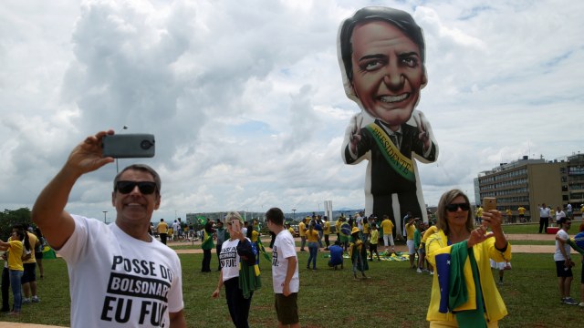Para pendukung Presiden baru Brasil Jair Bolsonaro berfoto dengan balon raksasa berbentuk Jair Bolsonaro. (Foto: REUTERS/Amanda Perobelli)