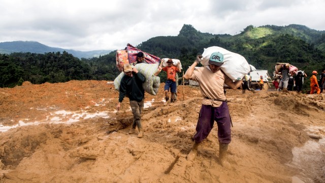 Warga memindahkan barang-barang yang tersisa saat longsor di kampung Cimapag, Desa Sirnaresmi, Kecamatan Cisolok, Kabupaten Sukabumi, Jawa Barat, Rabu (2/1/2019). (Foto: ANTARA FOTO/M Agung Rajasa)