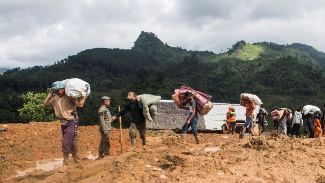 Warga memindahkan barang-barang yang tersisa saat longsor di kampung Cimapag, Desa Sirnaresmi, Kecamatan Cisolok, Kabupaten Sukabumi, Jawa Barat, Rabu (2/1/2019). (Foto: ANTARA FOTO/M Agung Rajasa)