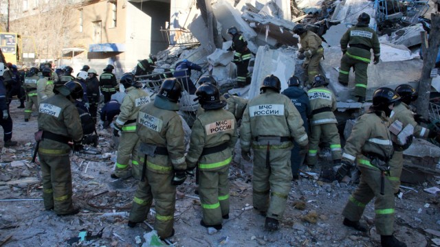 Sejumlah petugas mengevakuasi puing-puing reruntuhan apartemen akibat ledakan gas di Magnitogorsk, Rusia.   (Foto:  AFP/Ilya MOSKOVETS )
