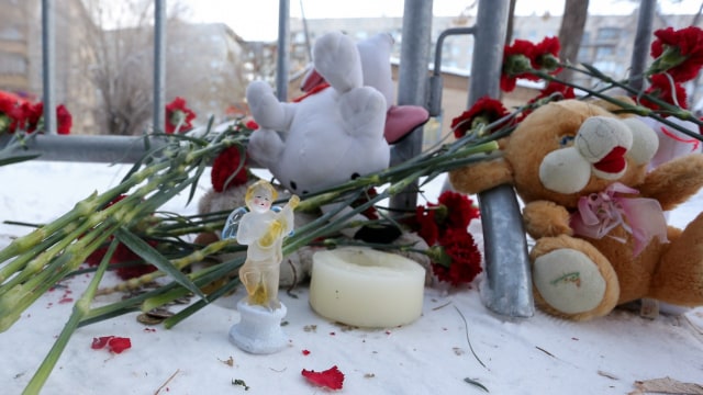 Sejumlah mainan dan bunga tergeletak di lokasi ledakan apartemen akibat gas di Magnitogorsk, Rusia. (Foto: AFP/STR)