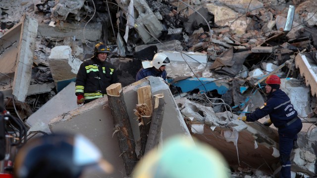 Sejumlah petugas mengevakuasi puing-puing reruntuhan apartemen akibat ledakan gas di Magnitogorsk, Rusia.   (Foto:  AFP/STR)