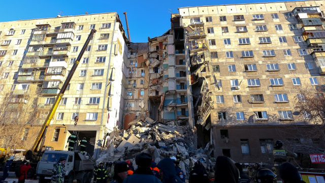 Sejumlah petugas mengevakuasi puing-puing reruntuhan apartemen akibat ledakan gas di Magnitogorsk, Rusia.   (Foto:  AFP/STR)