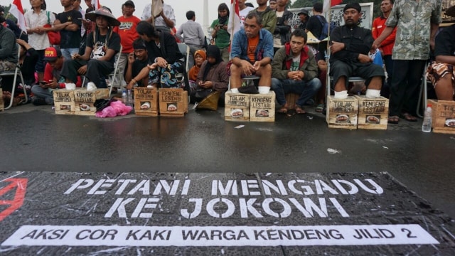 Aksi Petani Pegunungan Kendeng, Kabupaten Rembang, Jawa Tengah, mencor kaki dengan semen di depan Istana Negara, Jakarta, Jum'at (17/3/2017).  (Foto: Aditia Noviansyah/kumparan)