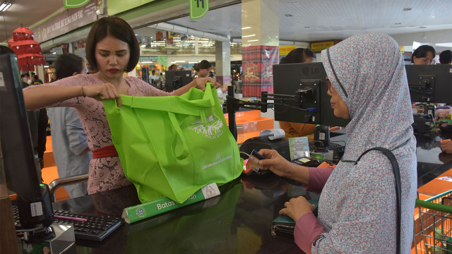 Karyawan swalayan mengemas barang belanjaan konsumen dengan tas ramah lingkungan di pusat perbelajaan di Denpasar, Bali. Foto: ANTARA FOTO/Nyoman Hendra Wibowo