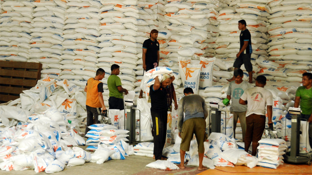 Pekerja memindahkan beras medium untuk kebutuhan operasi pasar awal tahun 2019 di gudang Perum Bulog. Foto: ANTARA FOTO/Ampelsa