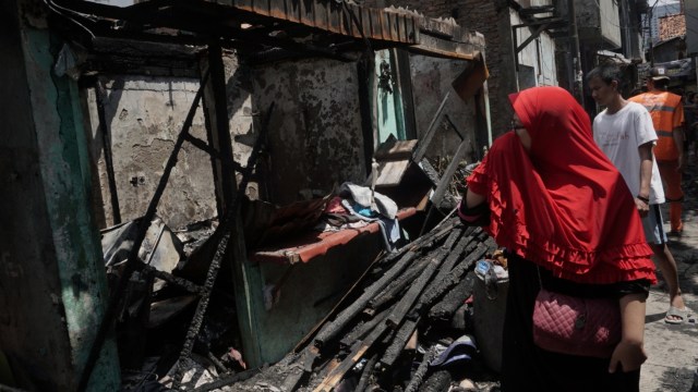 Seorang warga melihat kondisi lokasi kebakaran kawasan padat penduduk Kelurahan Tambora, Jakarta Barat. (Foto: Fanny Kusumawardhani/kumparan)