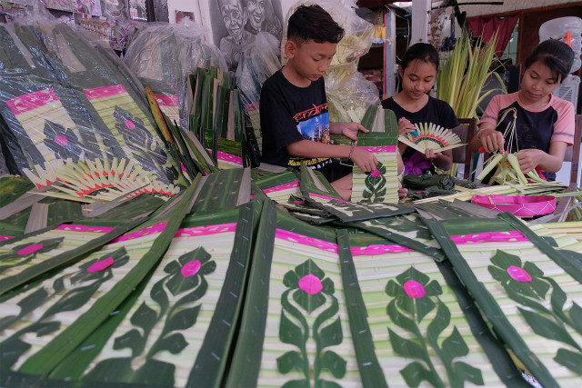 Sejumlah anak merangkai janur dan daun aren untuk sarana upacara persembahyangan menjelang Hari Raya Galungan dan Kuningan. (Foto: ANTARA FOTO/Nyoman Hendra Wibowo)
