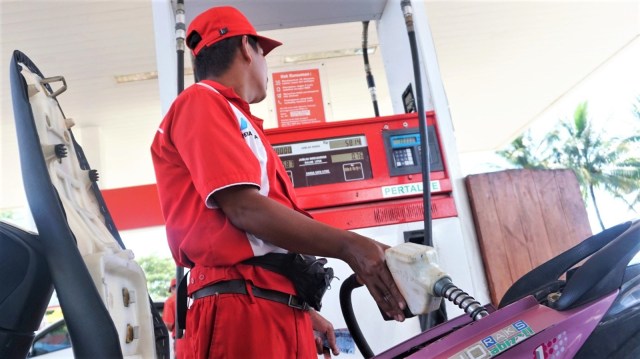 Petugas SPBU sedang melayani pembeli bahan bakar untuk kendaraan roda dua. Foto: Irfan Adi Saputra/kumparan