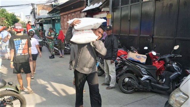 Sejumlah warga Jelambar membawa beras untuk dimasak. (Foto: Fitra Andrianto/kumparan)