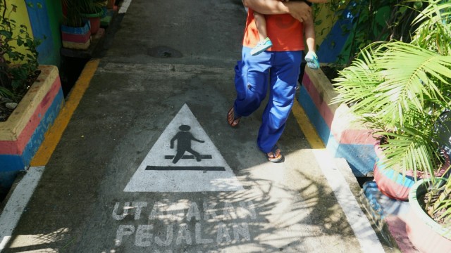 Sejumlah orang berjalan di Kampung Kangkungan, Kelurahan Sunter Jaya, Jakarta Utara. (Foto: Nugroho Sejati/kumparan)