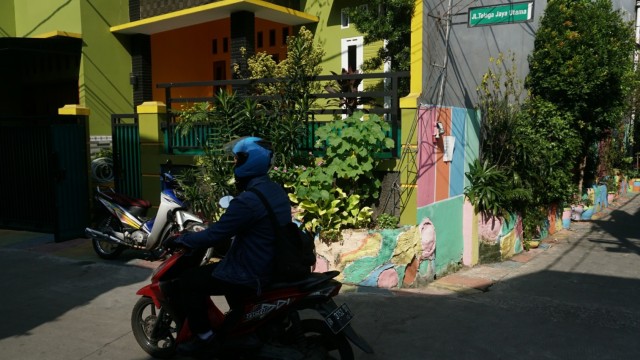 Seorang warga mengendari kendaraan motor melintas di Kampung Kangkungan, Kelurahan Sunter Jaya, Jakarta Utara. (Foto: Nugroho Sejati/kumparan)