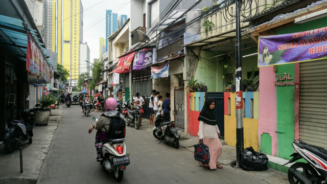 Sejumlah orang berjalan di Kampung Kangkungan, Kelurahan Sunter Jaya, Jakarta Utara. (Foto: Nugroho Sejati/kumparan)