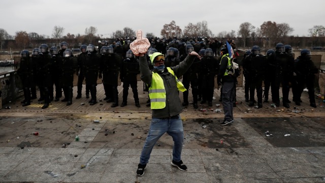 Seorang demonstran anti pemerintah "Rompi Kuning" saat berhadapan dengan polisi di Paris, Prancis, pada Sabtu (5/1/2019). (Foto: AFP/Sameer Al-Doumy )
