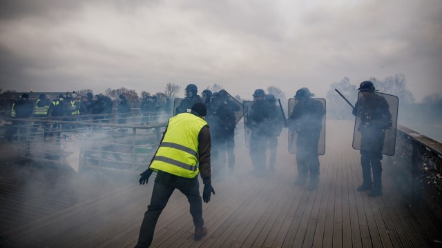 Seorang demonstran anti pemerintah "Rompi Kuning" saat berhadapan dengan polisi di Paris, Prancis, pada Sabtu (5/1/2019). (Foto: AFP/Abdul ABEISSA)