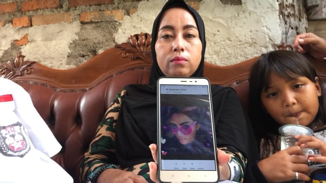 Seorang ibu menunjukan foto Nurhayati, wanita yang tewas di Apartemen Green Pramuka.  (Foto: Fachrul Irwinsyah/kumparan)