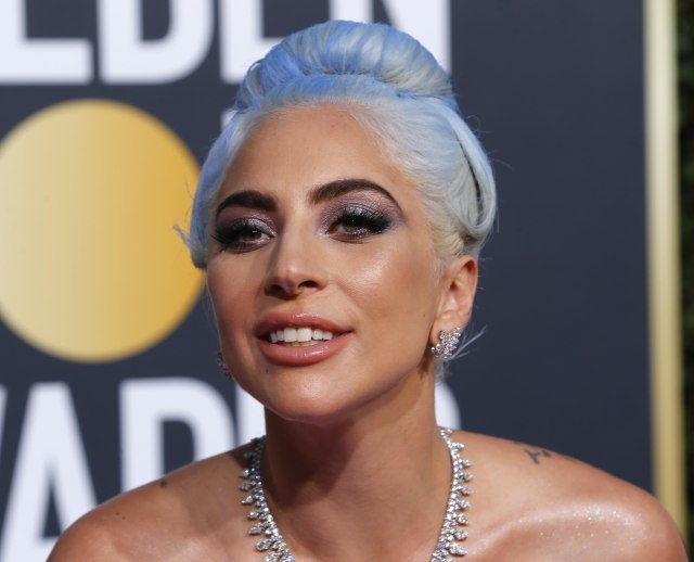 Eyeshadow glitter bernuansa ungu dan abu-abu menjadi poin utama makeup Lady Gaga. Foto: REUTERS/Mike Blake