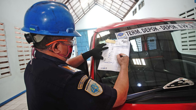 Petugas memeriksa kelayakan kendaraan saat uji kendaraan umum di Tempat Uji KIR. Foto: ANTARA FOTO/ Kahfie kamaru