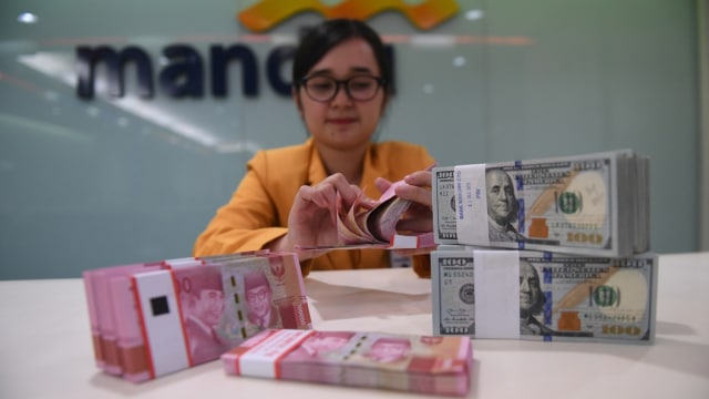 Seorang Teller menghitung uang Rupiah dan Dolar Amerika Serikat di Bank Mandiri, Jakarta, Senin (7/1/2018). Rupiah ditutup menguat 1,26 persen menjadi Rp14.085 per satu Dolar AS. (Foto: ANTARA FOTO/Akbar Nugroho Gumay)