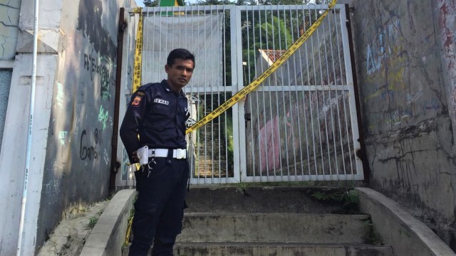 Seorang petugas keamanan setempat, Irwan menjaga TKP pembunuhan Andriana, seorang siswi SMK di Jl Riau, Bogor Timur. (Foto: Lutfan Darmawan/kumparan)