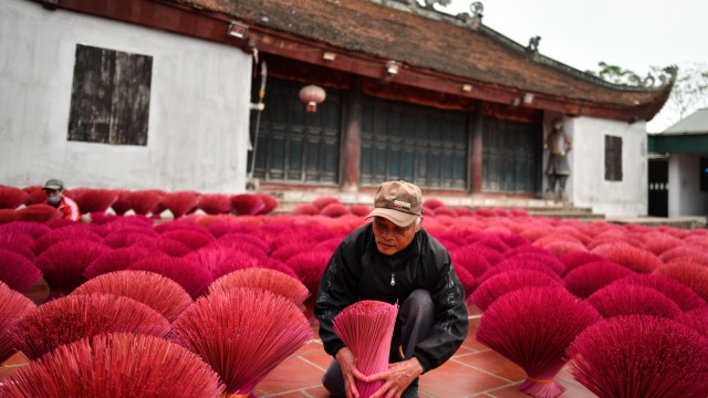 Seorang pekerja sedang mengeringkan batang bambu yang telah diproses, Desa Quang Phu Cau, Hanoi, Vietnam. (Foto: AFP/Manan VATSYAYANA)