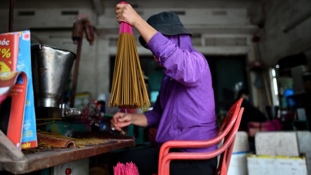 Para pekerja mempersiapkan batang bambu untuk diproses menjadi dupa, Desa Quang Phu Cau, Hanoi, Vietnam. (Foto: AFP/Manan VATSYAYANA)