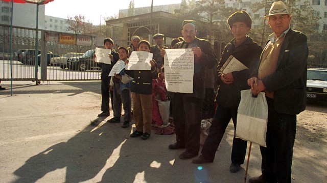 Anggota keluarga pedagang Uighur yang terbunuh mencari keadilan dengan memprotes petisi di luar gedung pemerintah Xinjiang di ibukota Urumqi. (Foto: AFP)