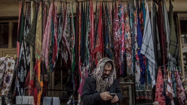 Seorang penjual toko saat memainkan telepon genggamnya di Hasankeyf, Turki. (Foto: AFP/BULENT KILIC)