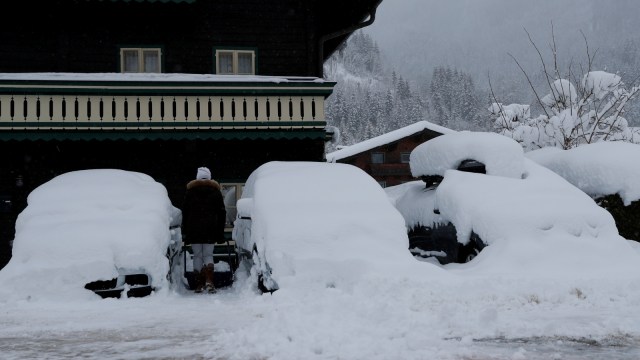 Warga membersihkan salju di jalan Flachau, Austria.
 (Foto: REUTERS/Leonhard Foeger)