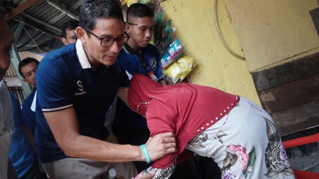 Sandiaga Uno membantu seorang lansia berdiri, di Tambora, Jakarta (10/1). (Foto: Jamal Ramadhan)