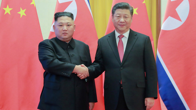 Pemimpin Korea Utara Kim Jong Un berjabat tangan dengan Presiden Cina Xi Jinping. (Foto: Kantor Berita Pusat Korea (KCNA)/Reuters)