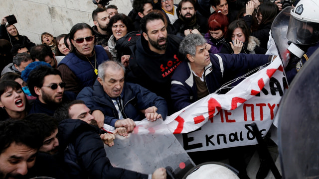 Para guru sekolah Yunani bentrok dengan polisi anti huru hara selama demonstrasi di depan gedung parlemen di sektor publik di Athena, Yunani. (Foto: Reuters/Costas Baltas)