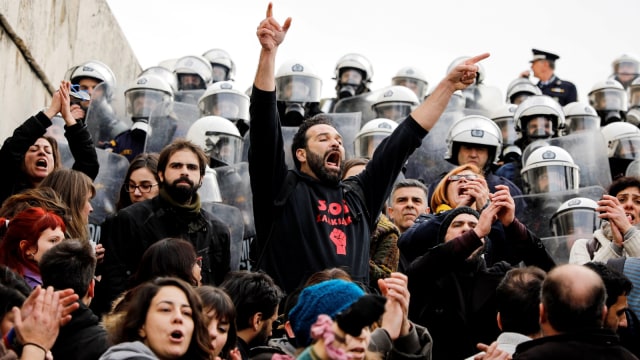 Para pengunjuk rasa meneriakkan slogan-slogan ketika mereka menghadapi polisi selama berdemo di Athena. (Foto: Reuters/Alkis Konstantinidis)