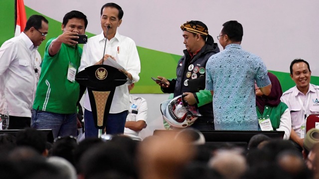 Presiden Joko Widodo (tengah) melayani permintaan swafoto oleh pengemudi online disela-sela Silatnas Keluarga Besar Pengemudi Online di Jakarta. (Foto: Antara/Puspa Perwitasari)