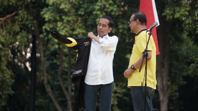 Jokowi mengenakan jaket pemberian Alumni UI (Foto: Jamal Ramadan/kumparan)