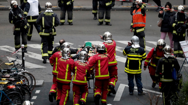 Petugas pemadam kebakaran Paris mengevakuasi korban yang terluka karena ledakan akibat kebocoran gas di toko roti, Sabtu (12/1/2019). (Foto: REUTERS/Benoit Tessier)