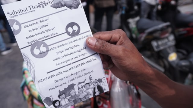 Selebaran berisi pesan harmoni dalam perbedaan diberikan Sahabat Thamrin di CFD, Jakarta, Minggu (13/1). (Foto: Jamal Ramadhan/kumparan)