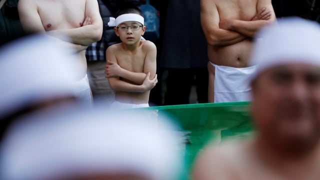 Seorang anak ikut serta dalam upacara memurnikan jiwa kuil Teppozu Inari di Tokyo. (Foto:  REUTERS/Issei Kato)