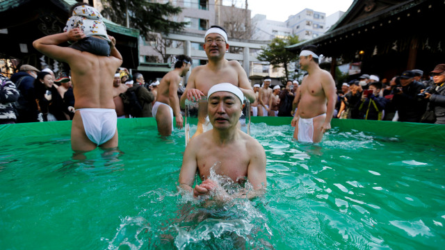 Sejumlah orang berdoa saat mandi air dingin dalam upacara memurnikan jiwa kuil Teppozu Inari di Tokyo. (Foto:  REUTERS/Issei Kato)